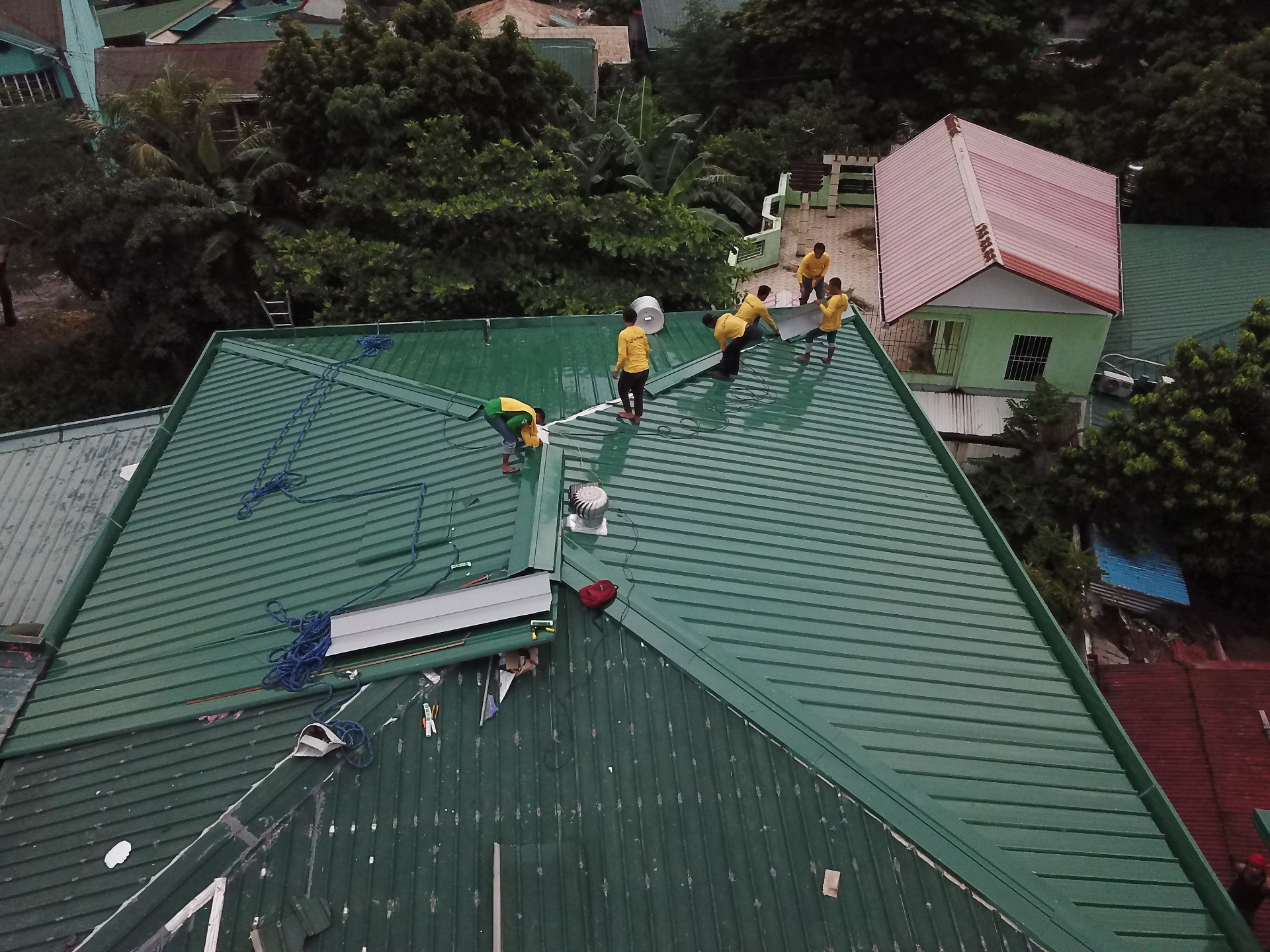 Roofing crew installing a metal roof on a commercial building